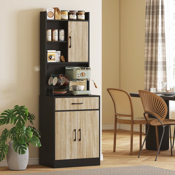 Moderner hoher Küchenschrank mit schwarzem Korpus und hellen Fronten in Holzoptik, genutzt als Kaffeestation in einem hellen Raum.