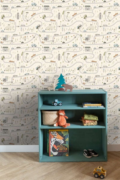 Kindertapete mit Straßen und Autos Motiv an einer Wand mit einem blauen Regal mit Spielzeug in einem Kinderzimmer.