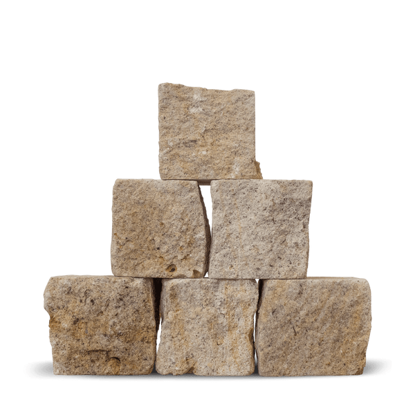 Pflastersteine aus Naturstein in Beige-Grau, Würfelform mit rauer Oberfläche, gestapelt.