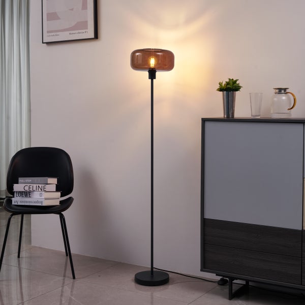 Stehlampe mit Glasschirm neben einem Schrank und einem Stuhl im Raum.