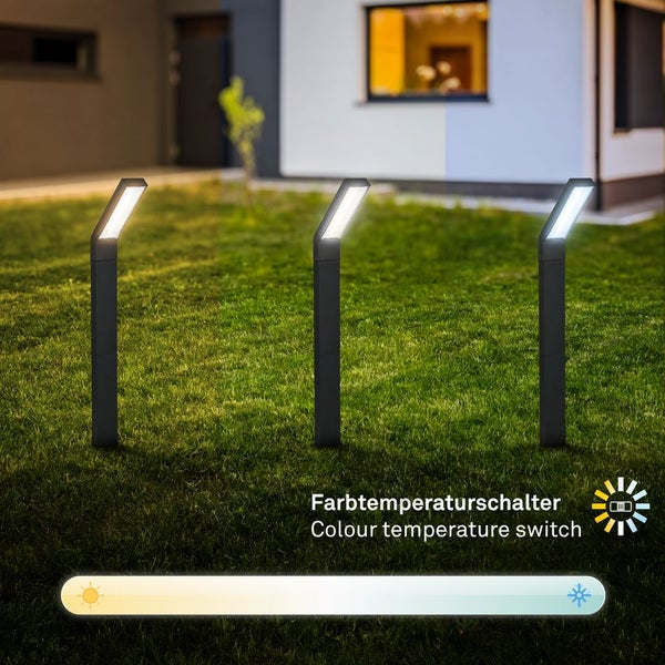 Drei moderne schwarze LED-Wegeleuchten auf Rasen mit Farbtemperaturschalter und Darstellung von warmweißem bis kaltweißem Licht.