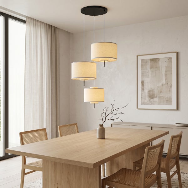 Moderne Pendelleuchte mit drei zylindrischen Stoffschirmen über einem Holzesstisch in einem hellen, skandinavisch eingerichteten Esszimmer.