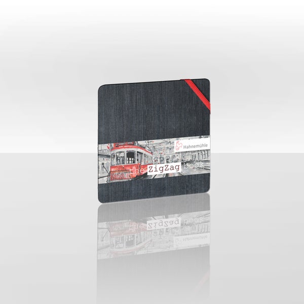 Hahnemühle The ZigZag Book Skizzenbuch, quadratisch, mit dunklem Textileinband, rotem Gummibandverschluss und Hahnemühle Logo.