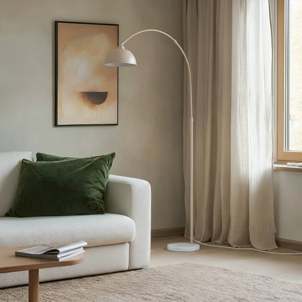 Wohnzimmer mit Bogenleuchte, Sofa, Kissen, Bild und Vorhängen