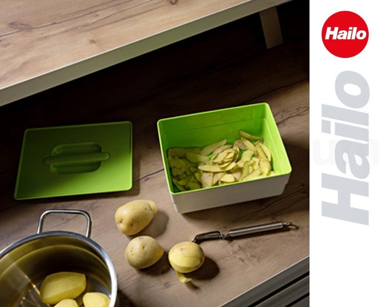 Grüner Hailo Bio-Abfalleimer mit Deckel, Kartoffelschalen, Kartoffeln, Sparschäler und Topf auf einer Holzarbeitsplatte. Hailo Logo.