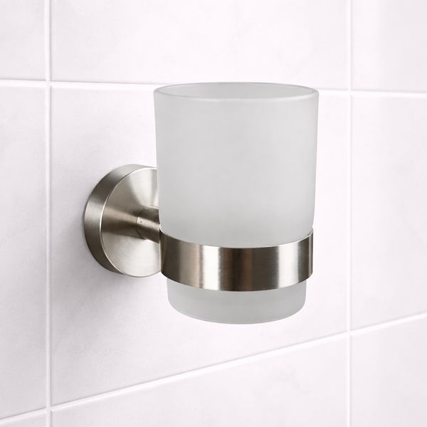 Wandmontierter Zahnputzbecherhalter aus gebürstetem Metall mit einem Becher aus satiniertem Glas.