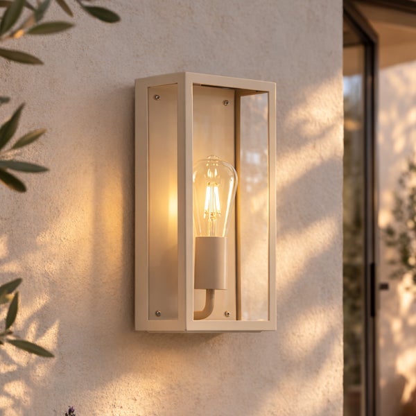 Cremeweiße rechteckige Außenwandleuchte aus Metall und Glas mit leuchtender LED-Filamentlampe an einer strukturierten Wand.