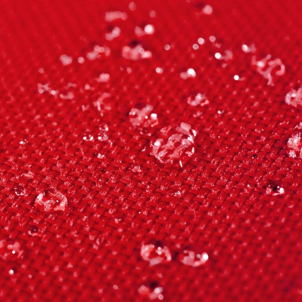 Wassertropfen auf wasserabweisendem Textilgewebe mit erkennbarer Webstruktur