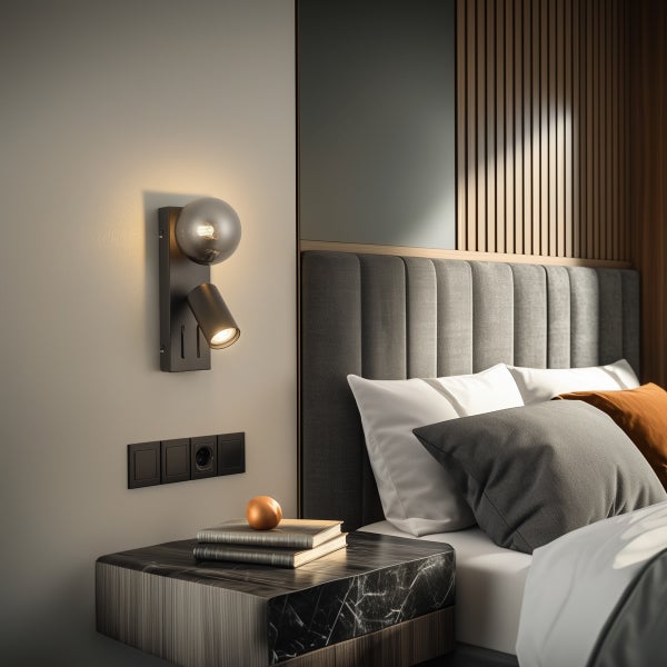 Moderne Wandleuchte mit Glaskugel und Lesespot in einem Schlafzimmer neben einem gepolsterten Kopfteil und Nachttisch.