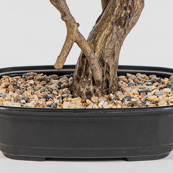 Künstliche Pflanze mit grün-weiß gemusterten Blättern und braunem Stiel.