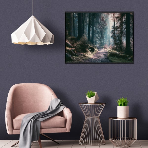 Ein moderner Wohnbereich mit einem gepolsterten Sessel, zwei Beistelltischen, einer Pendelleuchte und einem Wandbild mit Waldmotiv.
