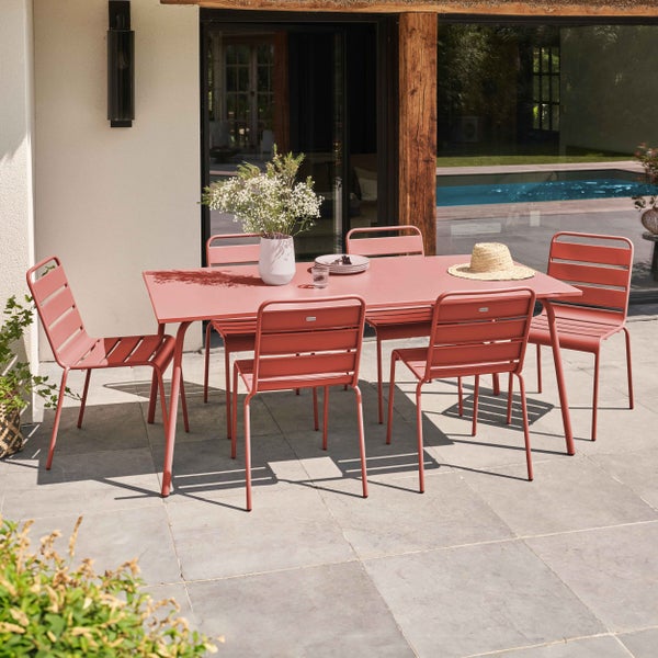 Moderne Garten-Sitzgruppe aus Metall mit einem rechteckigen Tisch und sechs Stühlen auf einer hellen Fliesenterrasse am Pool.