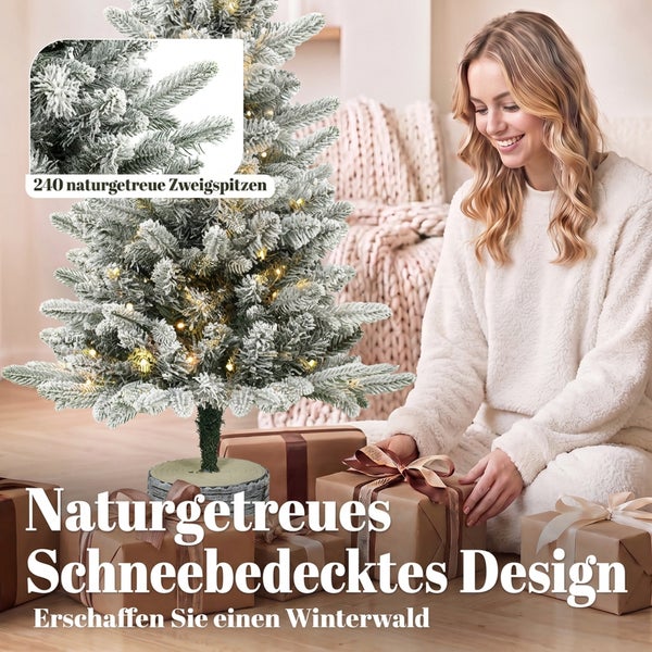 Künstlicher Weihnachtsbaum mit 240 Zweigspitzen und Schneeoptik, dekoriert mit Lichterkette, neben einer Frau mit Weihnachtsgeschenken.