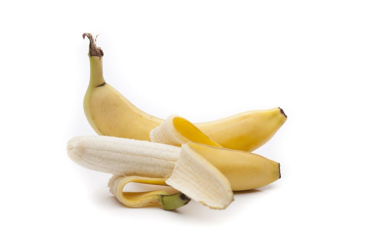 Eine geschälte Banane und eine ungeschälte Banane auf weißem Hintergrund.