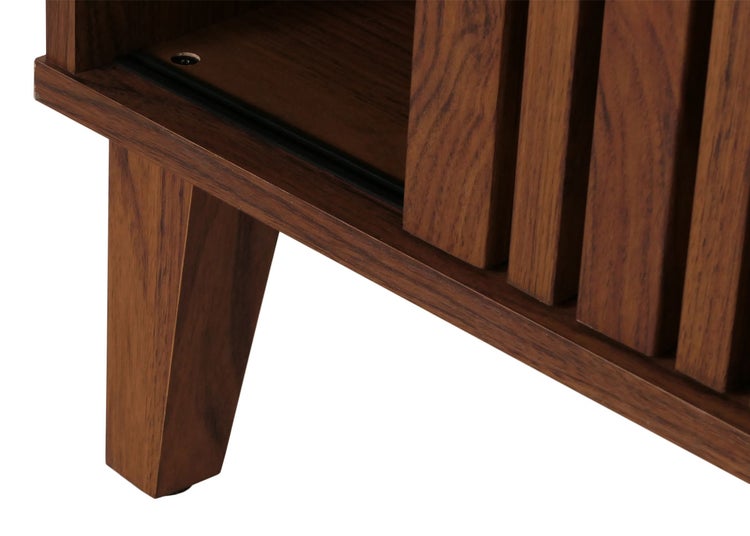 Detailaufnahme eines Holzschranks mit Lamellentüren und Holzfüßen.