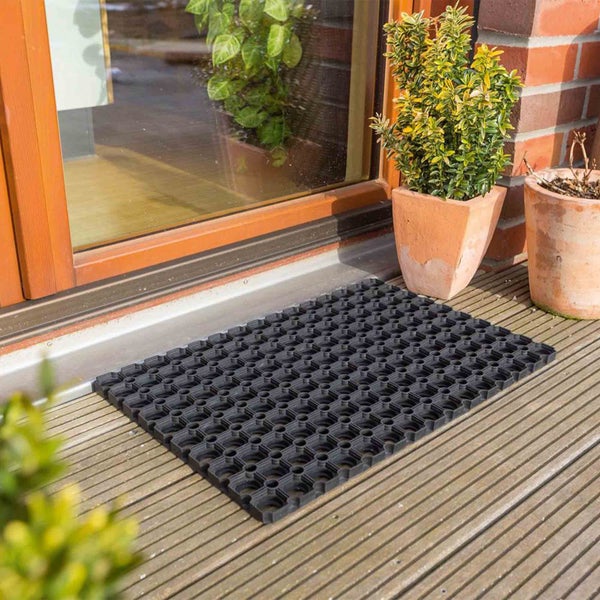 Gummimatte mit Lochmuster vor einer Haustür