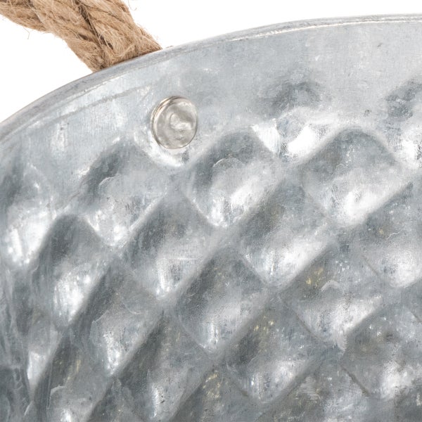 Nahaufnahme eines verzinkten Metallkübels mit Rautenmuster und Griff aus Seil.