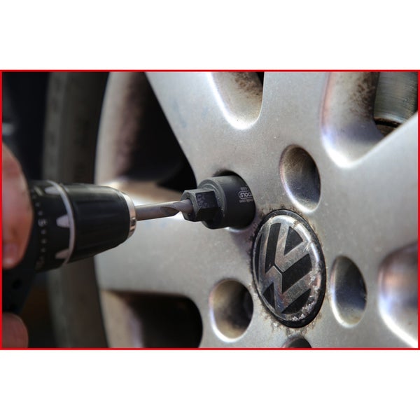 Radmutterndemontage mit einem Bohrer an einem Fahrzeugrad mit Volkswagen Logo