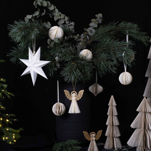 Dekoratives Weihnachtsarrangement mit Papierornamenten, darunter Sterne, Kugeln und Engel, sowie stilisierten Papierbäumen.
