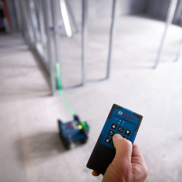 Bosch Logo. Eine Person bedient eine Fernbedienung für einen Baulaser.