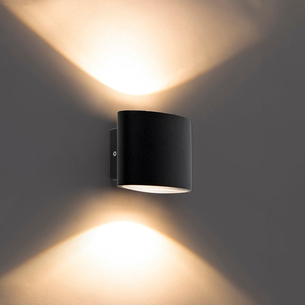 Wandleuchte in Schwarz mit Lichtaustritt nach oben und unten an einer Wand montiert.
