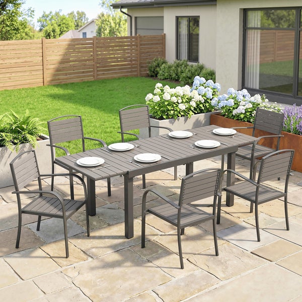 Moderne Garten-Essgruppe auf einer Steinterrasse bestehend aus einem anthrazitfarbenen Tisch und sechs Gartenstühlen mit Armlehnen.