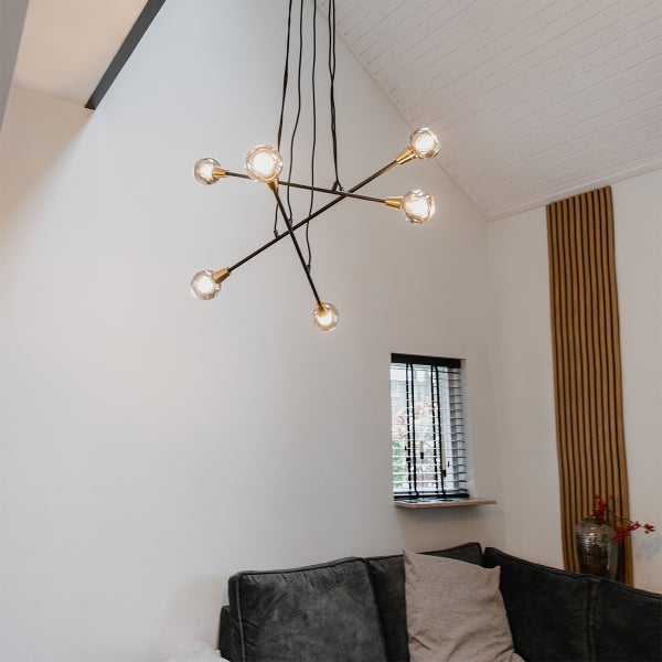 Deckenleuchte mit mehreren Armen und Glaskugeln in einem Wohnraum