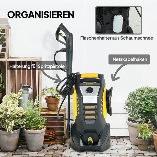 Hochdruckreiniger mit Halterung für Spritzpistole, Netzkabelhaken und Flaschenhalter inmitten von Topfpflanzen und Holzkisten.
