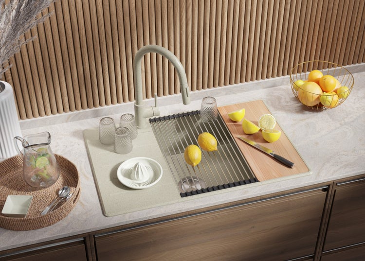 Küchenszene mit Spüle, Abtropfgestell, Schneidebrett und Zitrusfrüchten