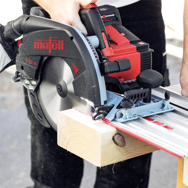 Eine Mafell K 85 18 Handkreissäge schneidet einen Holzbalken auf einer Führungsschiene.