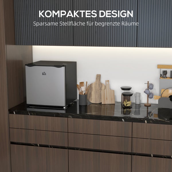Kompakter Minikühlschrank mit HOMCOM Logo auf einer dunklen Küchenarbeitsplatte. Modernes Küchendesign für begrenzten Platz.