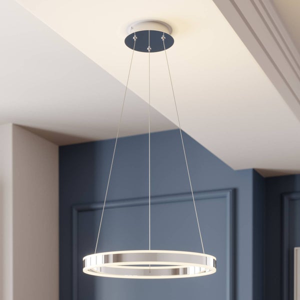 Moderne, ringförmige LED-Pendelleuchte aus Metall in Chrom-Optik, montiert an einer hellen Decke vor einer blauen Wand mit Wandleisten.