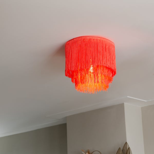 Neonfarbene Deckenleuchte mit Fransen im Wohnraum.