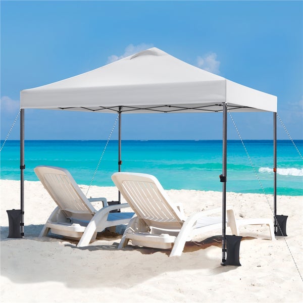 Strandszene mit einem weißen Pavillon und zwei Liegestühlen im Sand