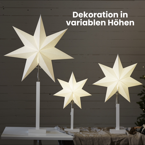 Drei Papiersterne mit variablem Fuß auf einem Tisch als Dekoration