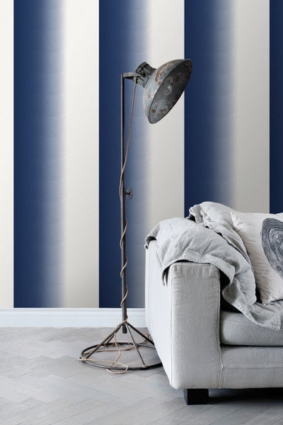 Einrichtungsszene mit gestreifter Tapete, Stehlampe und Sofa