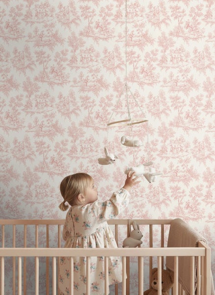 Vliestapete mit Toile-de-Jouy-Muster in einem Kinderzimmer mit Holzgitterbett und einem spielenden Kind.
