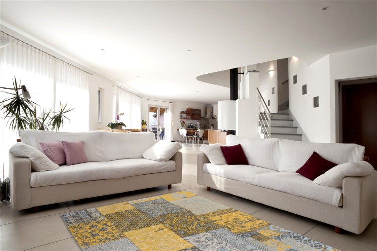 Offener, heller Wohnbereich mit zwei Sofas, Kamin und Fliesenboden sowie einem gemusterten Teppich im modernen Wohnraumdesign.