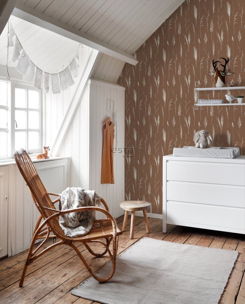 Kinderzimmer mit Wickelkommode, Rattansessel, Teppich und Tapete mit Pflanzenmuster