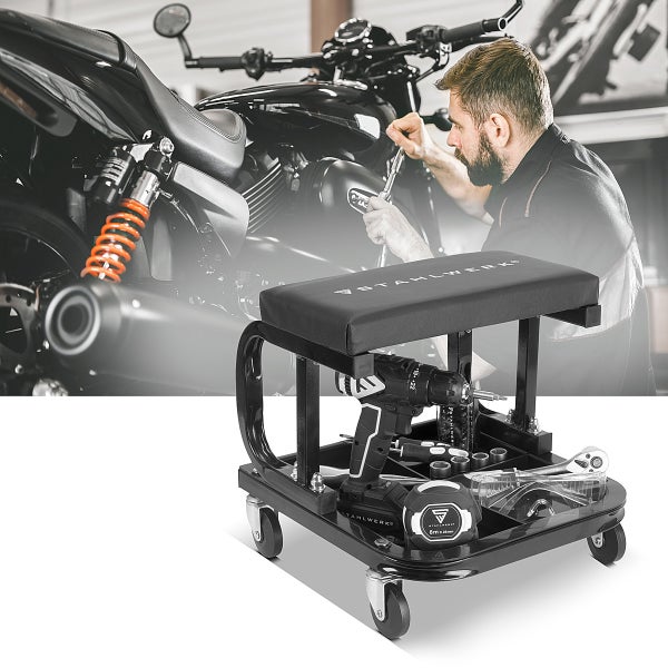 Werkstatthocker mit Werkzeugablage und Werkzeugen vor einem Motorrad