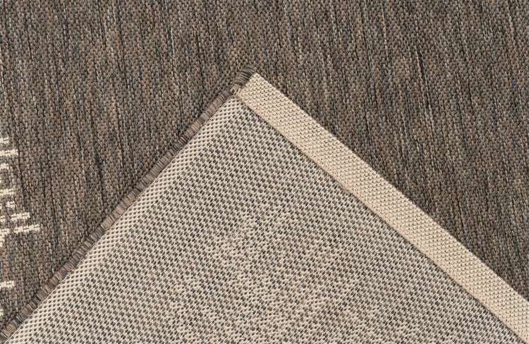 Detailansicht eines gewebten Teppichs mit sichtbarer Oberflächenstruktur und Teppichrücken.