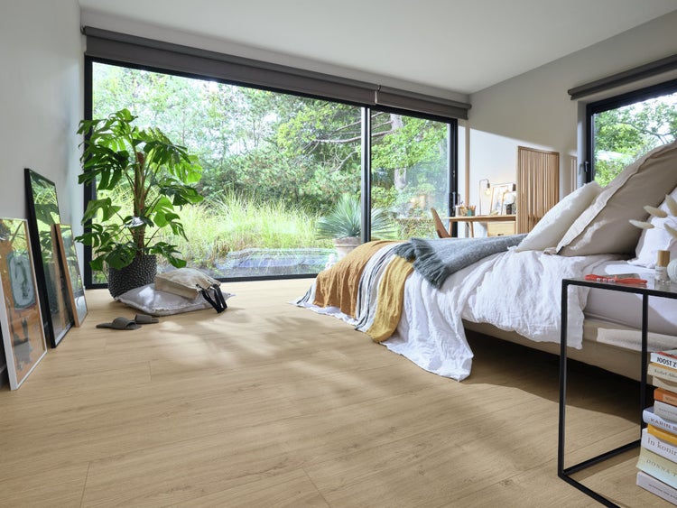 Modernes Schlafzimmer mit Eichenoptik Laminatboden, bodentiefen Fenstern und Blick in den Garten, helle und naturverbundene Wohnatmosphäre.