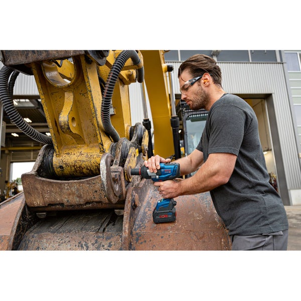 Ein Arbeiter verwendet einen Akku-Drehschlagschrauber an einem Bagger.