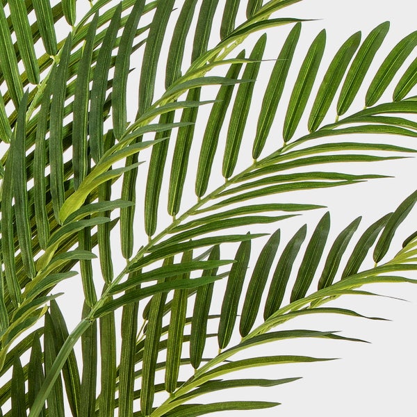 Detailaufnahme einer Kunstpflanze mit runden Blättern und naturgetreuen Stämmen.