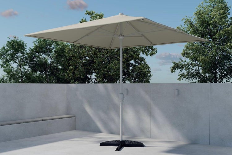 Rechteckiger Sonnenschirm in Creme auf einer hellen Terrasse mit Betonwand und schwarzem Schirmständer.