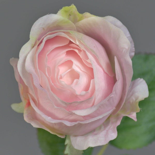 Künstliche Rosenblüte aus Textilmaterial in Rosa.