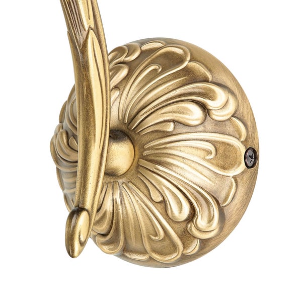 Detailaufnahme einer goldenen Wandhalterung mit floralem Muster