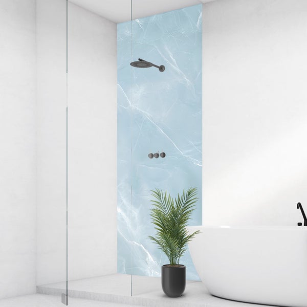 Modernes Badezimmer mit Duschrückwand in hellblauer Marmoroptik, schwarzer Duscharmatur, weißer Badewanne und einer Pflanze.
