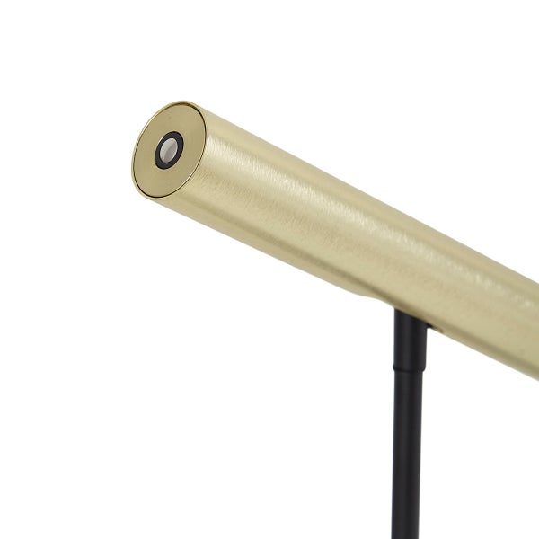 Detailansicht einer Leuchte mit goldfarbenem, zylindrischem Kopf aus gebürstetem Metall und schwarzem Ständer.