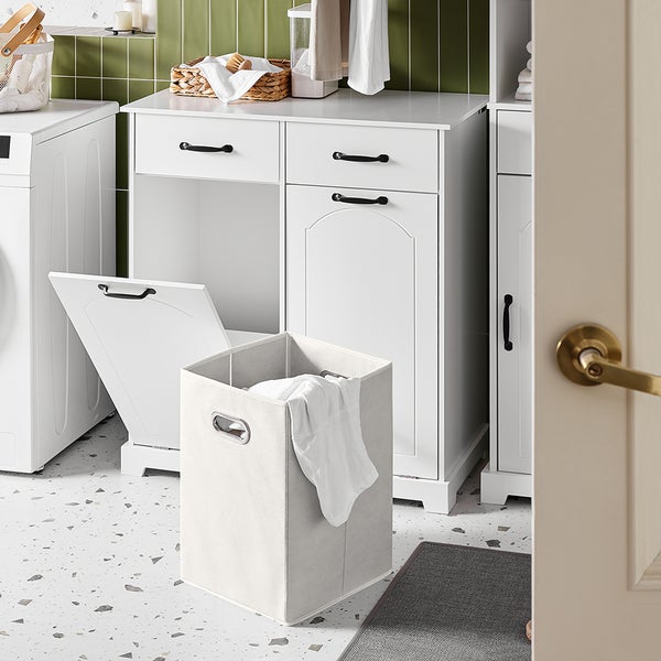 Heller Wäscheraum mit weißer Waschmaschine, Wäschekorb und weißen Schränken mit dunklen Griffen